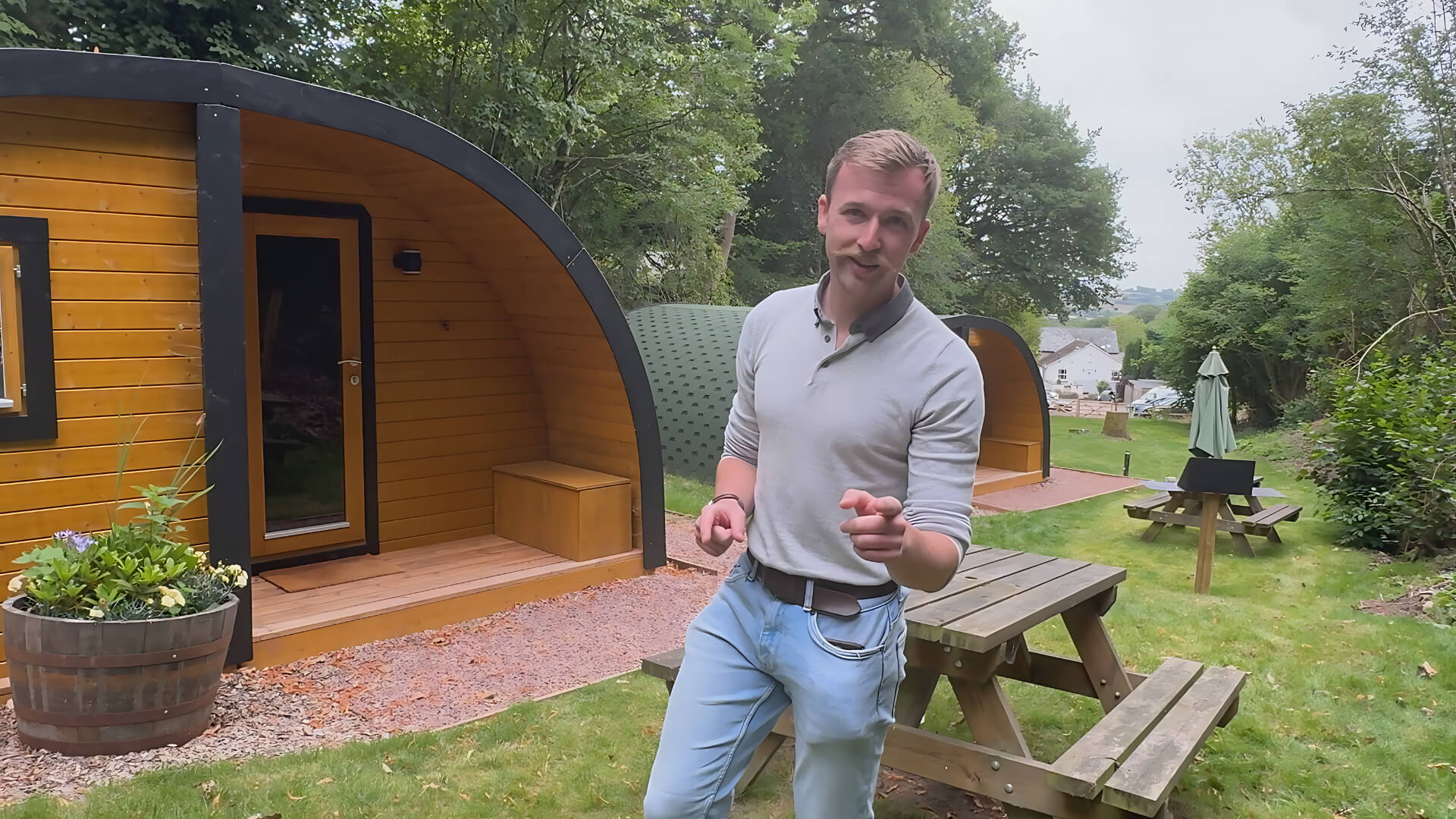 Taylor Glass, founder of GlampLaunch, standing in front of glamping pods on-site, highlighting the founder-led and personal approach to client projects.