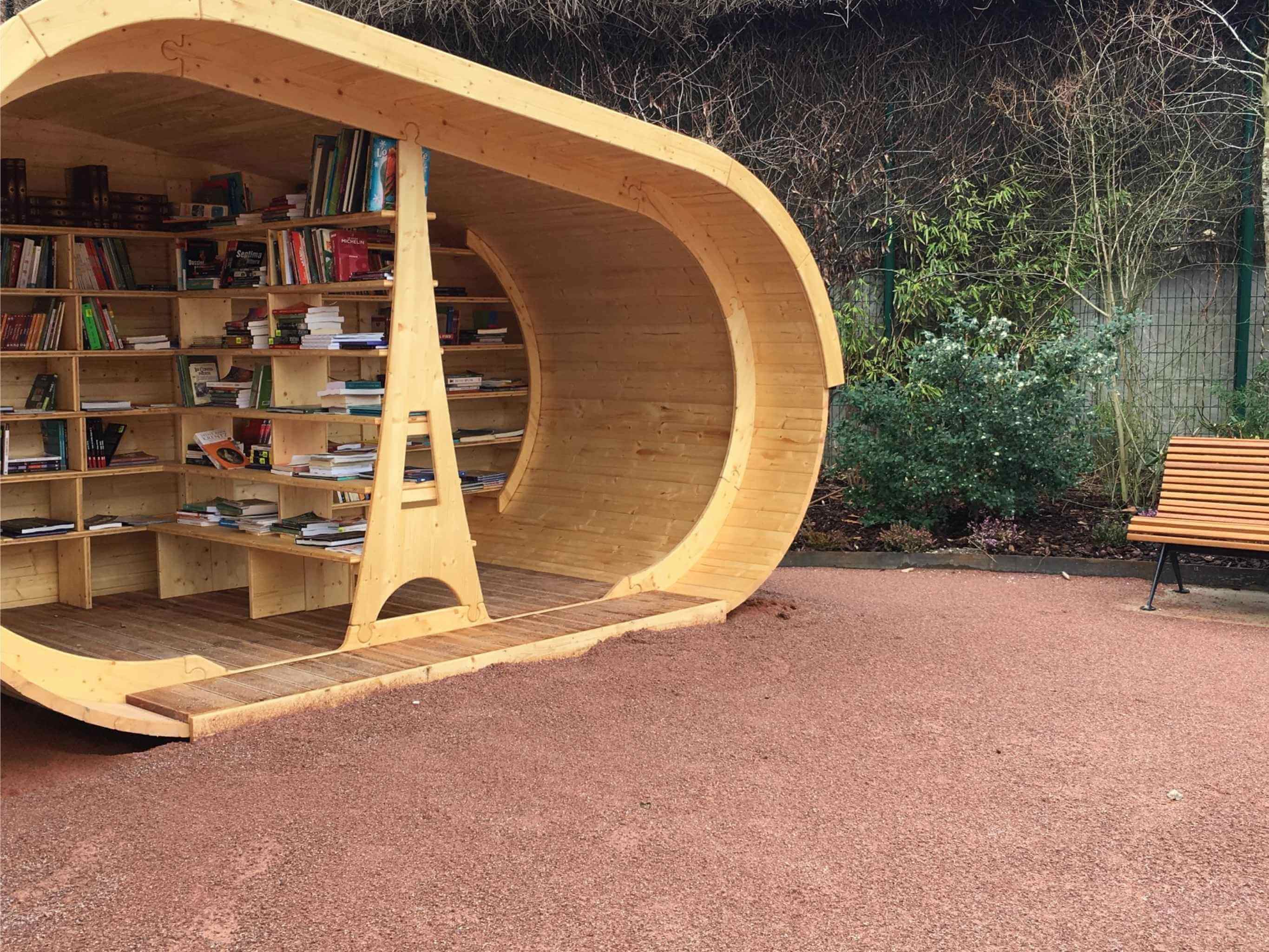 Wooden outdoor library pod with open shelving filled with books, designed by GlampLaunch as a reading and learning space.