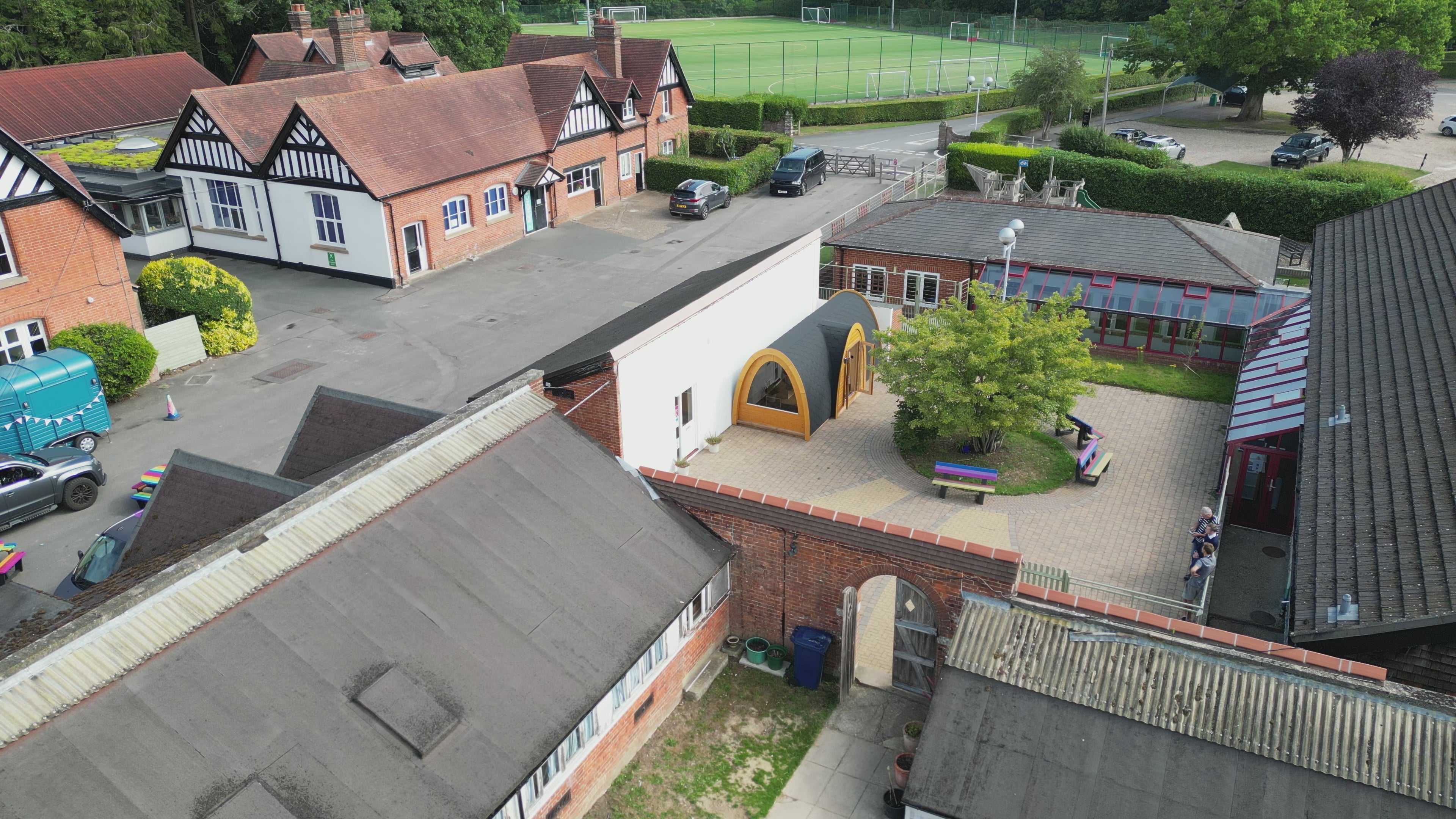 Drone video flying over Frensham Heights School, moving towards the custom GlampLaunch library pod in the courtyard.