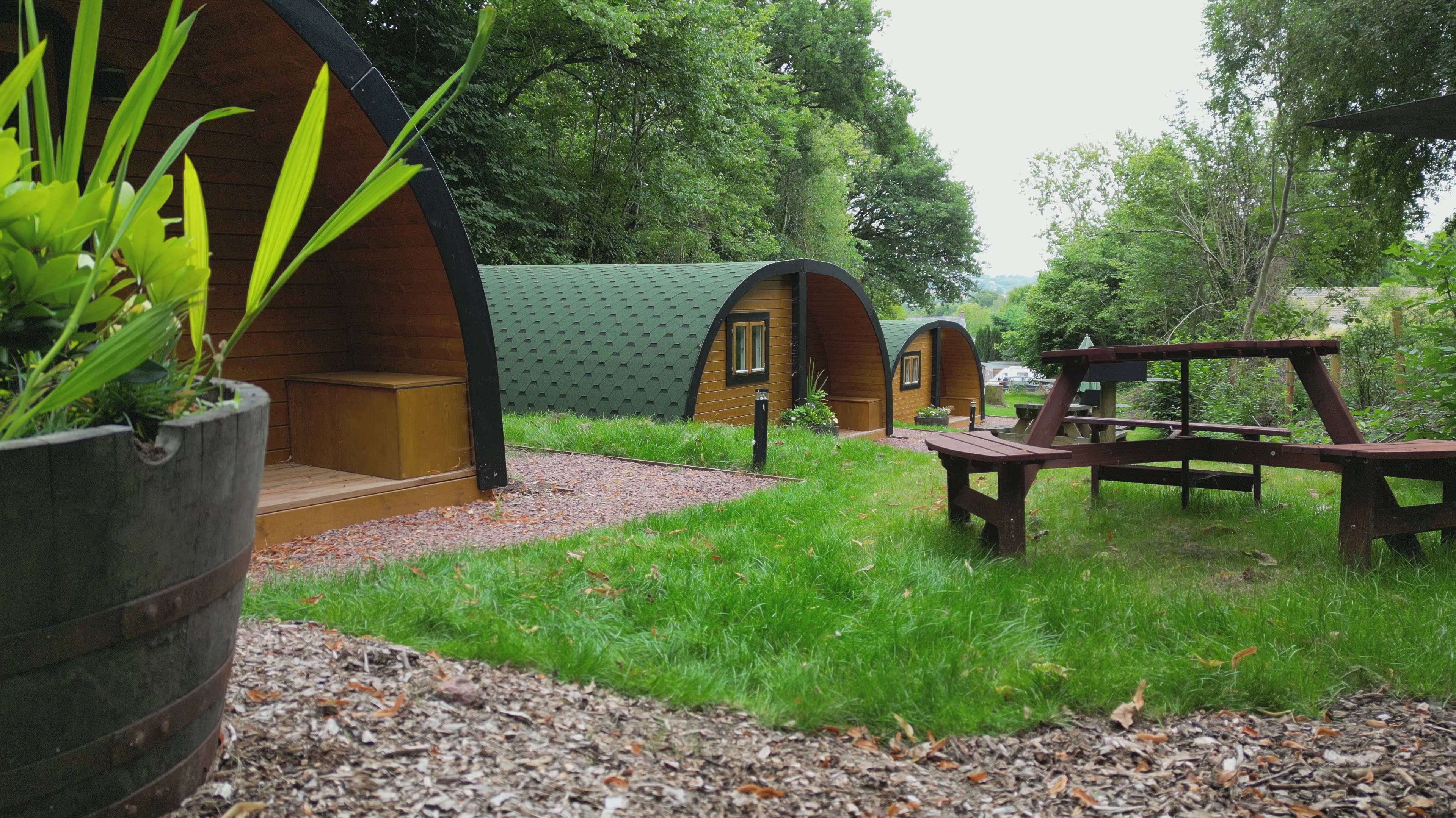 Drone view of three glamping pods at The Crown at Pantygelli, overlooking the Brecon Beacons countryside.