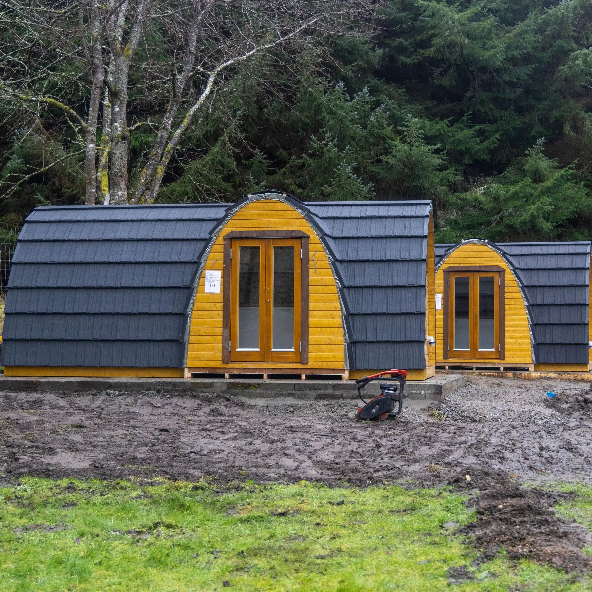 Finished glamping pods installed on a prepared site showing upgraded exterior design, insulation and construction quality improvements