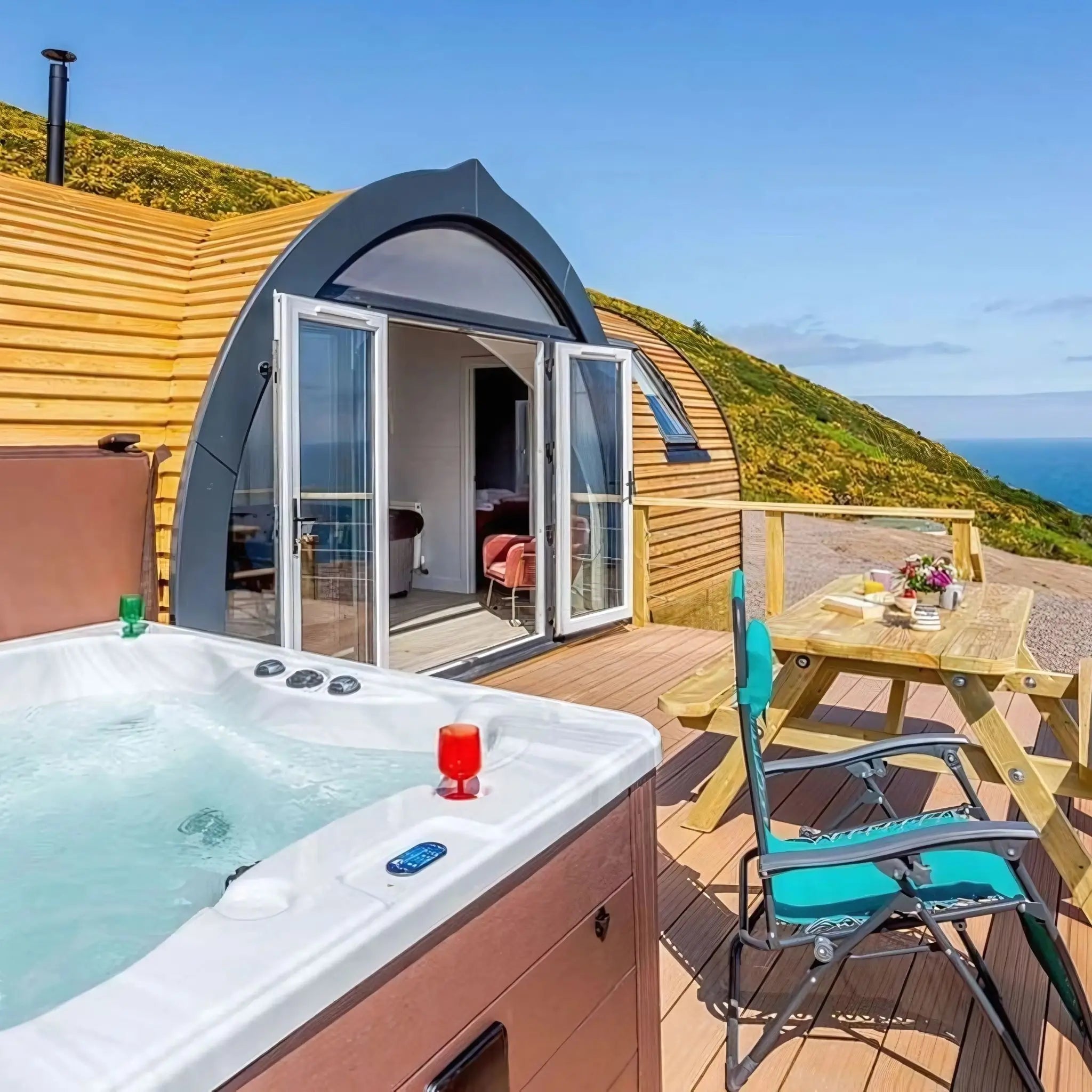 Spacious 4-person luxury hobbit pod with private hot tub and outdoor decking, showing why larger glamping pods cost more to insure.