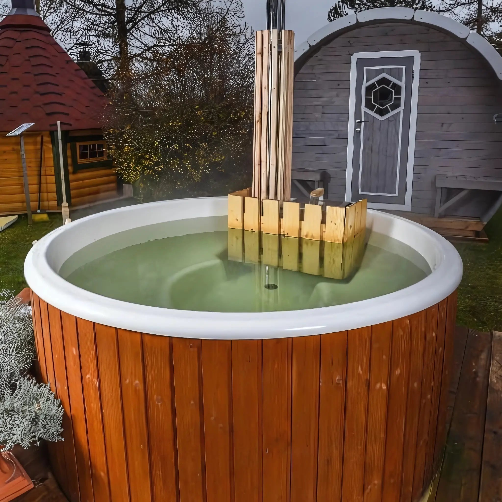 Luxury Ofuro 5–8 person Finnish hot tub outdoors beside glamping pods, showcasing a premium wellness feature perfect for boosting midweek bookings.