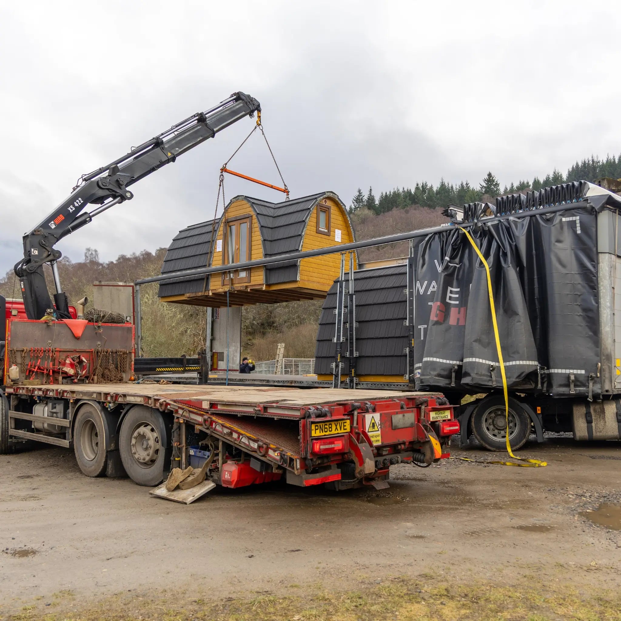 Crane unloading several glamping pods during one coordinated site delivery