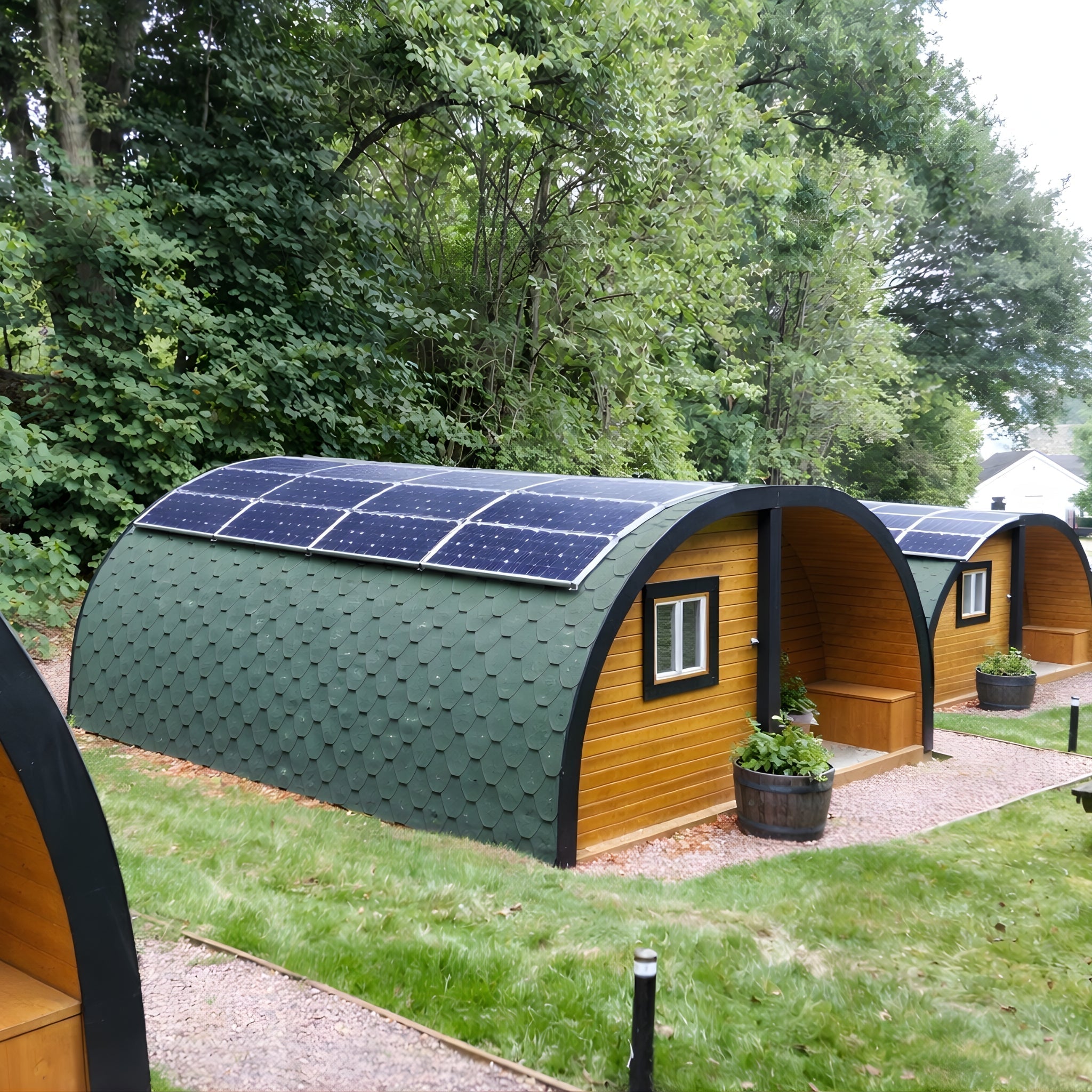 Timber glamping pods fitted with rooftop solar panels on a landscaped site, representing energy efficient design and sustainable operations for UK glamping accommodation.