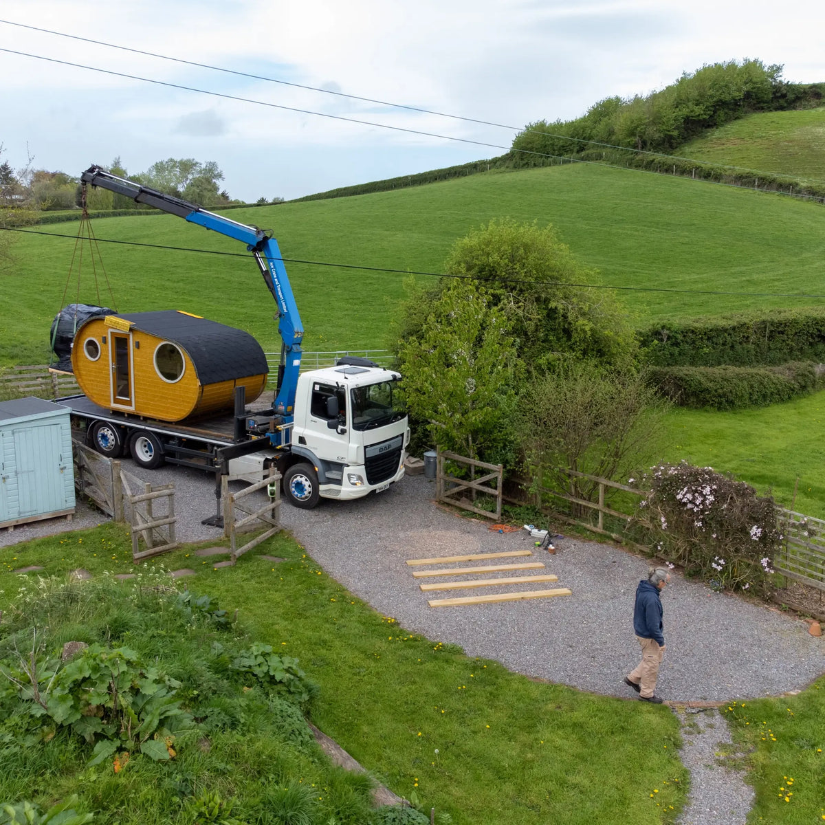 Luxury glamping pod being delivered and installed using a HIAB crane in the UK