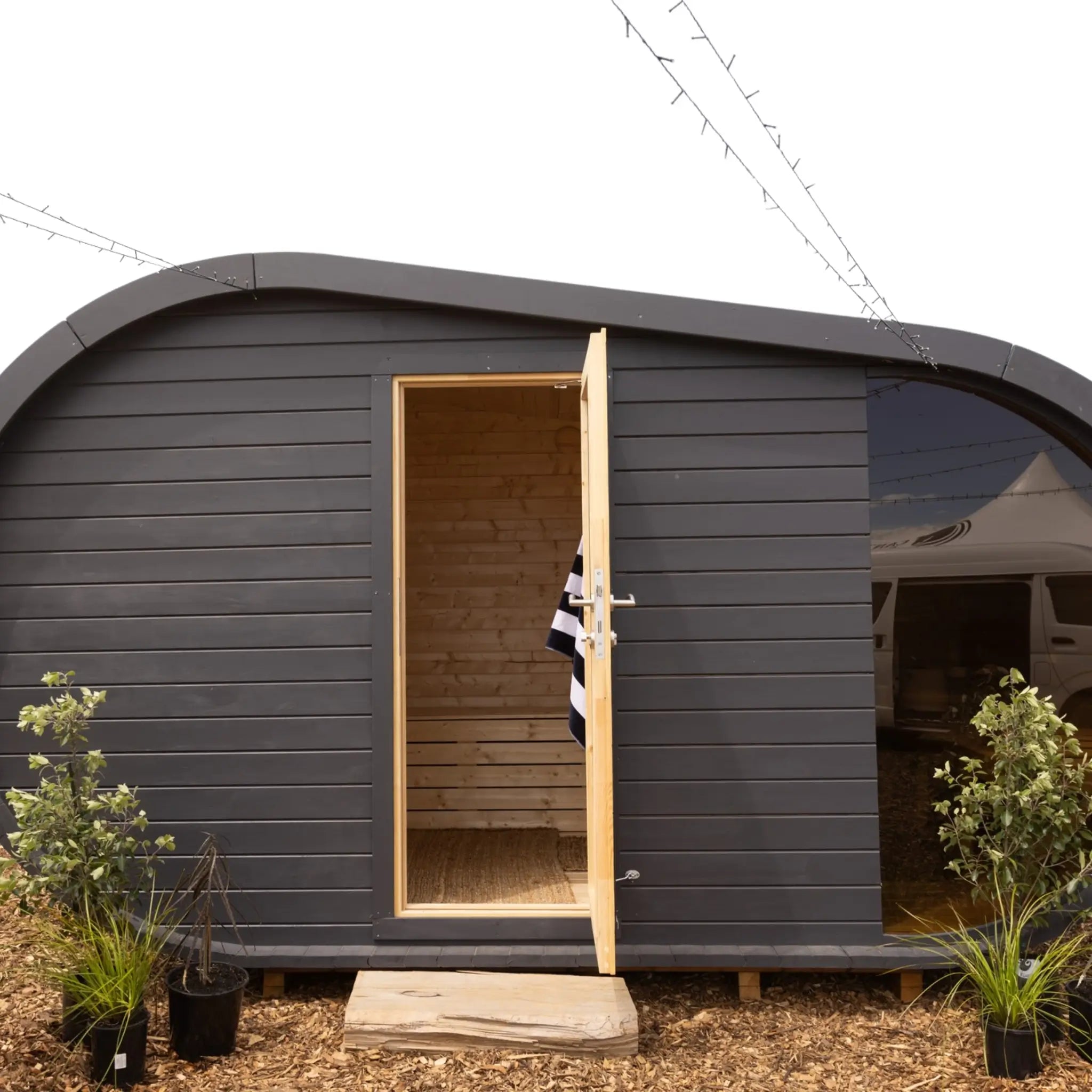 Front view of The Serenity luxury 6–8 person traditional outdoor sauna pod by GlampLaunch, featuring a black exterior and timber interior.