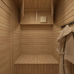 Changing room with open overhead storage cabinet inside 4 Person Traditional Outdoor Sauna Cube, featuring timber finishes and built-in bench seating.