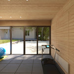 Interior view towards full glass frontage in 4 Person Traditional Outdoor Sauna Cube showcasing gym area, treadmill and bright open wellness space.