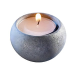 Hukka soapstone tealight holder with a lit candle, showing the rounded natural stone finish