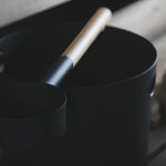 Close-up of black KOLO sauna pail and ladle with bamboo handle, showing the modern matte finish and minimalist design.