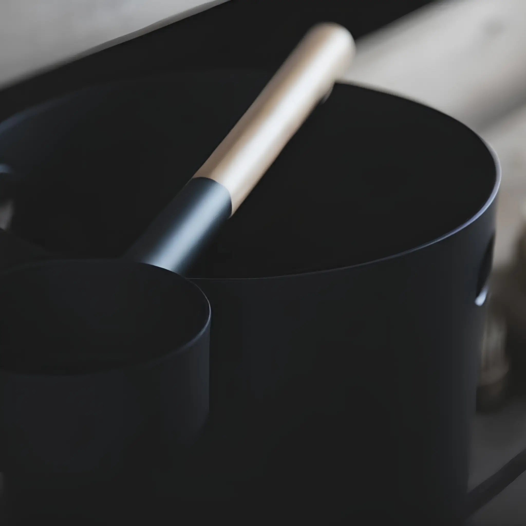 Close-up of black KOLO sauna pail and ladle with bamboo handle, showing the modern matte finish and minimalist design.