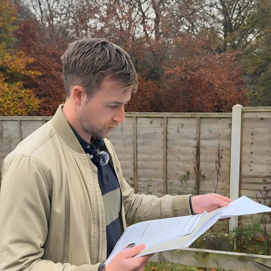Glamping land acquisition specialist reviewing site plans on location as part of a glamping land acquisition and site shortlisting report