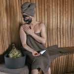 Rento Arctic Pine Sauna Honey applied during a relaxing sauna wellness ritual with traditional sauna whisk and wooden interior