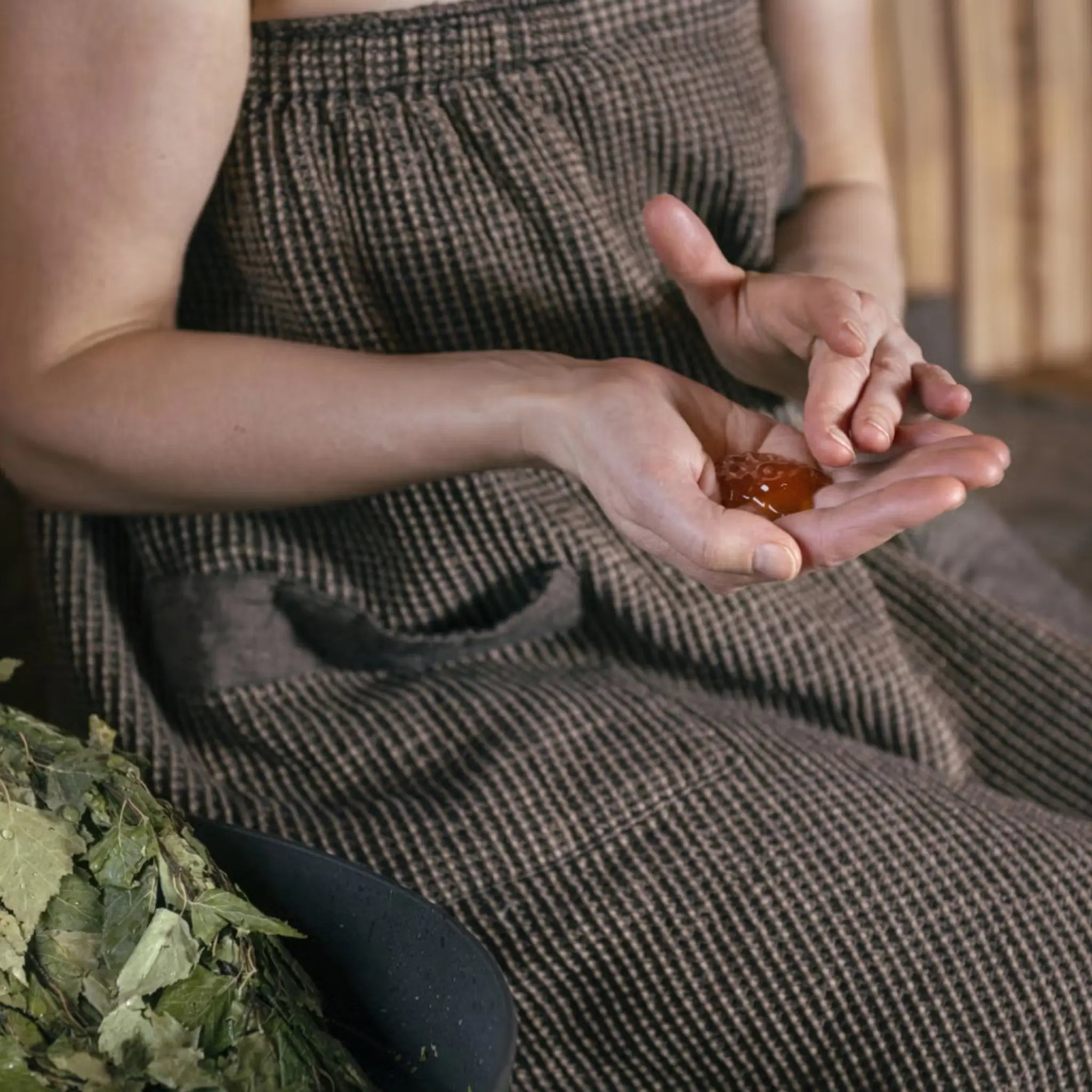 Close-up of nourishing Arctic Pine sauna honey being applied to skin during a luxury Finnish sauna skincare treatment