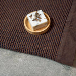 Rento Birch Soap 50g displayed on a wooden soap dish beside a brown sauna seat cover.