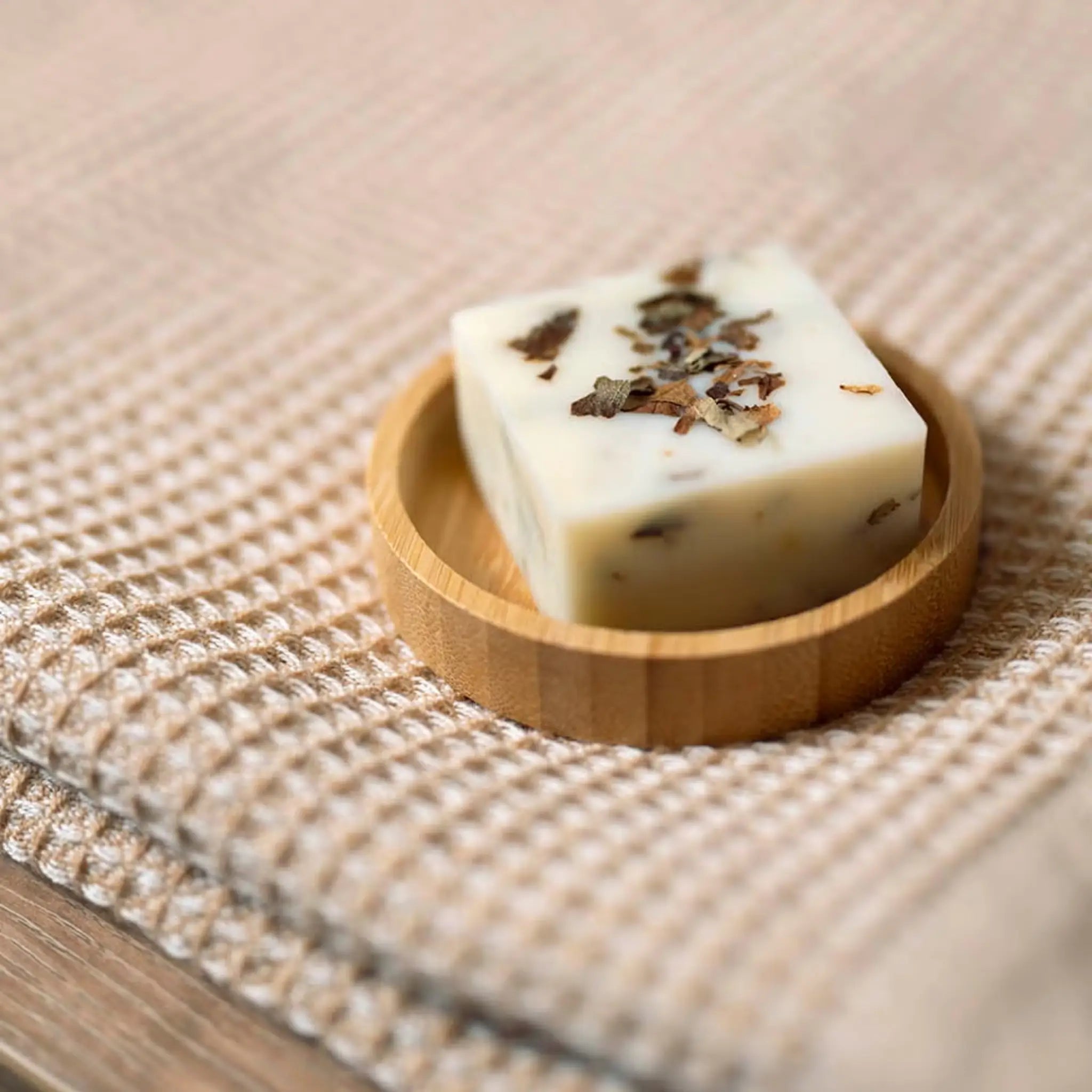 Rento Birch Soap 50g on a wooden soap dish placed on a textured sauna towel.