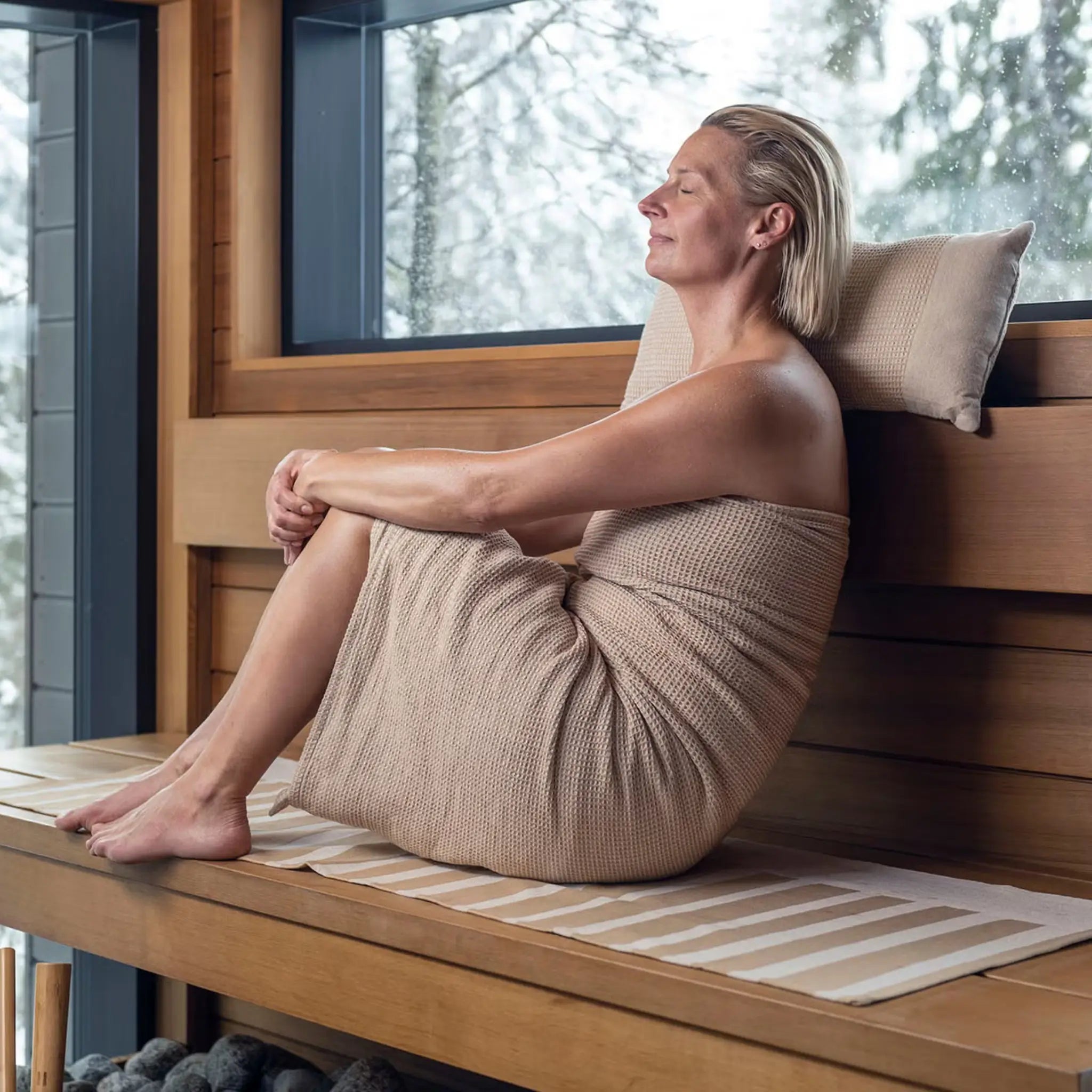 Beige Rento Kenno sauna pillow and matching striped seat cover used on a wooden sauna bench
