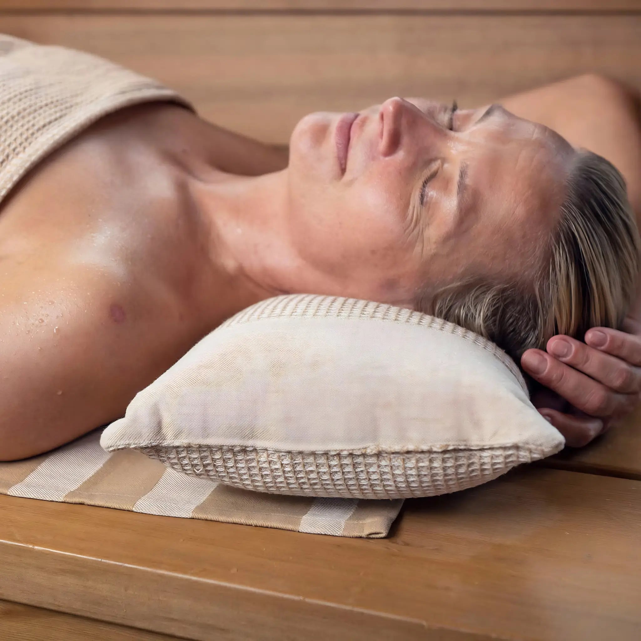 Close-up of beige Rento Kenno sauna pillow supporting the head during a relaxing sauna session