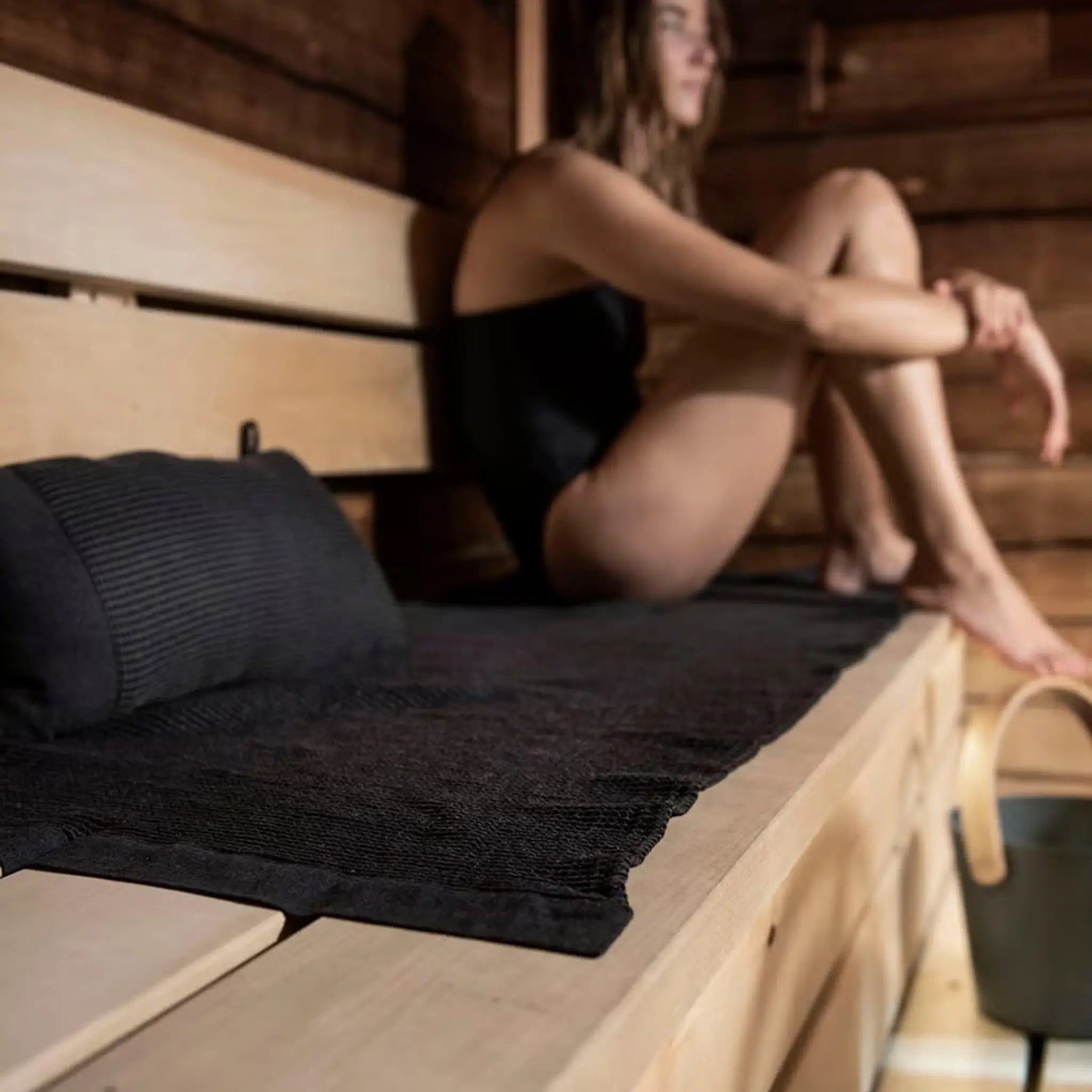 Black Rento Kenno sauna pillow and matching seat cover used for comfort inside a sauna room