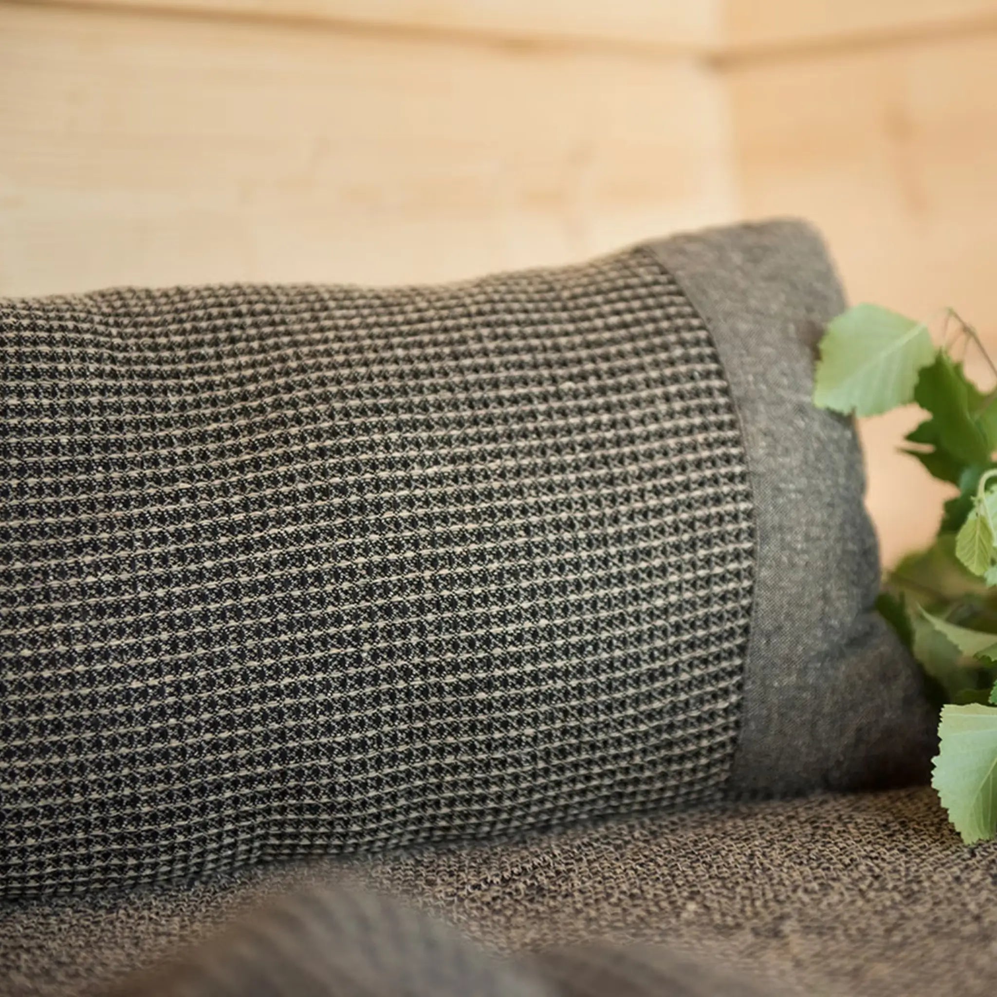 Brown Rento Kenno sauna pillow with matching seat cover and sauna accessories on a wooden bench