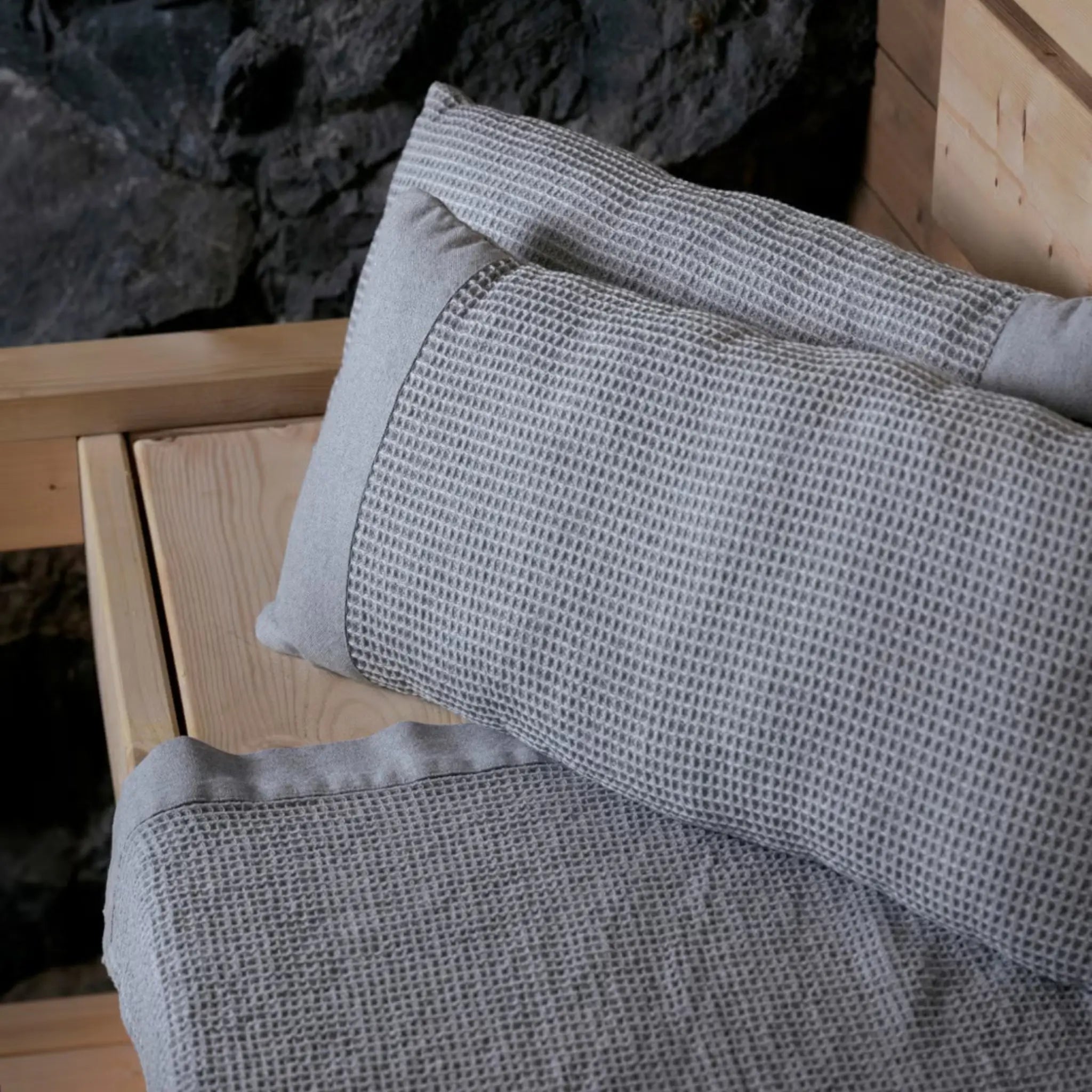 Grey white Rento Kenno sauna pillows and matching sauna seat cover inside a wooden sauna room