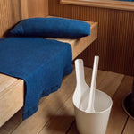 Dark blue Rento Kenno sauna seat cover and matching sauna pillow on a wooden sauna bench