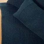 Dark green Rento Kenno sauna seat cover with matching sauna pillow on a sauna bench