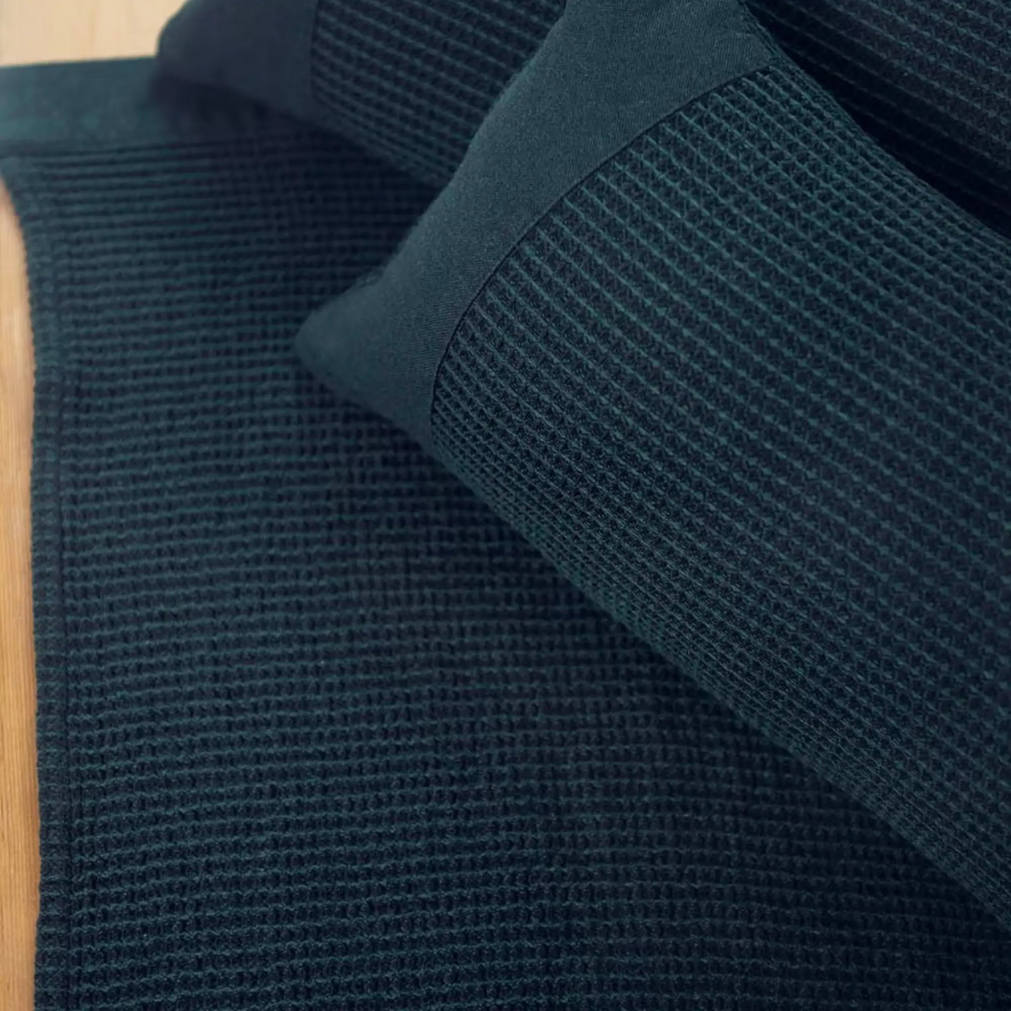 Dark green Rento Kenno sauna seat cover with matching sauna pillow on a sauna bench