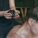 Rento peat salt soap held with sauna body brush during a cleansing ritual.
