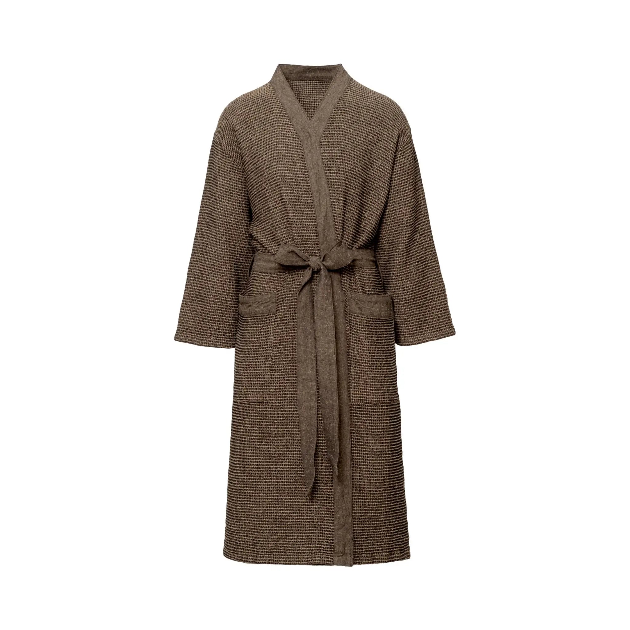 Adult wearing a brown Rento Kenno bathrobe outside a steaming sauna cabin