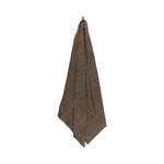 Brown large bath towel hanging on a white background with soft recycled cotton blend texture