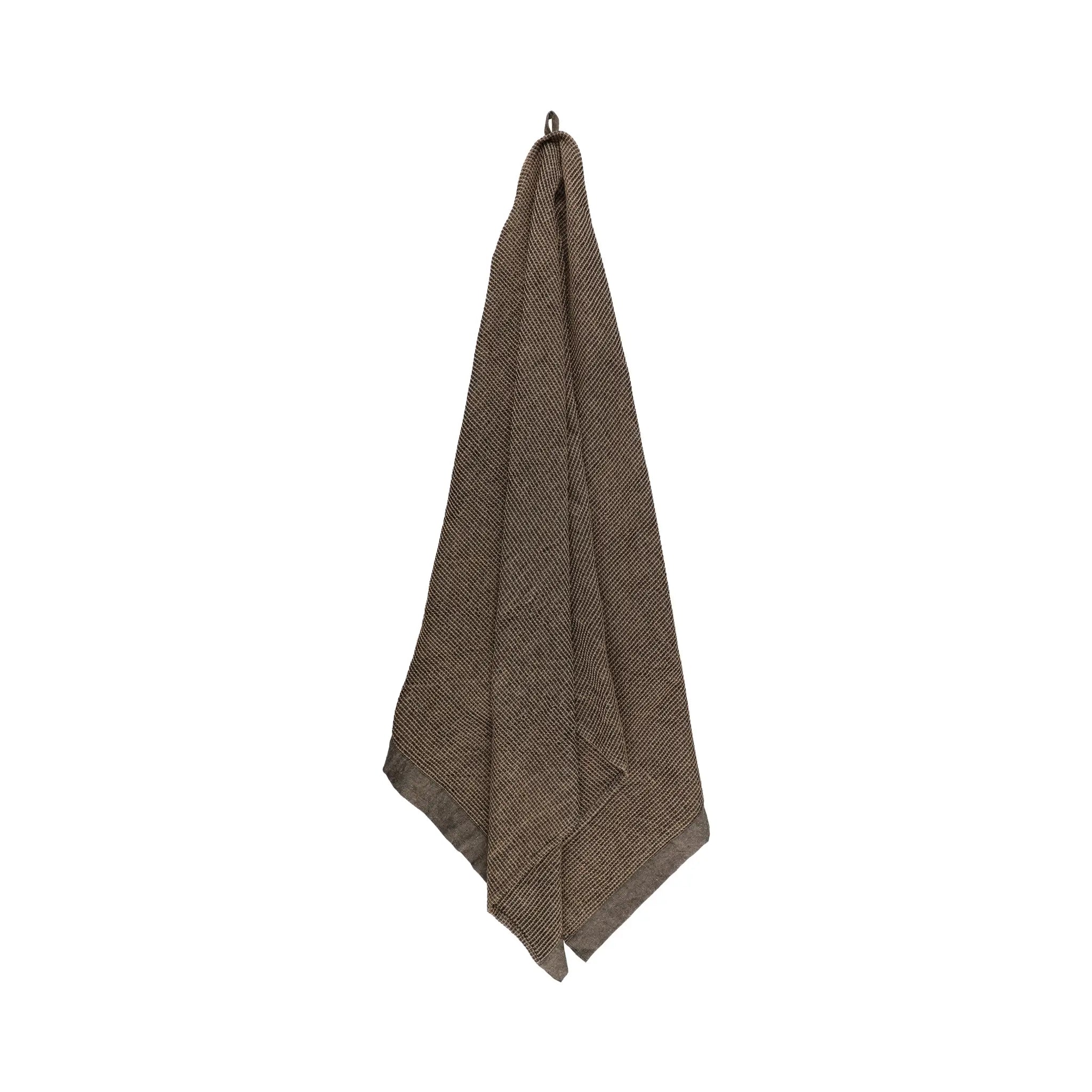 Brown large bath towel hanging on a white background with soft recycled cotton blend texture