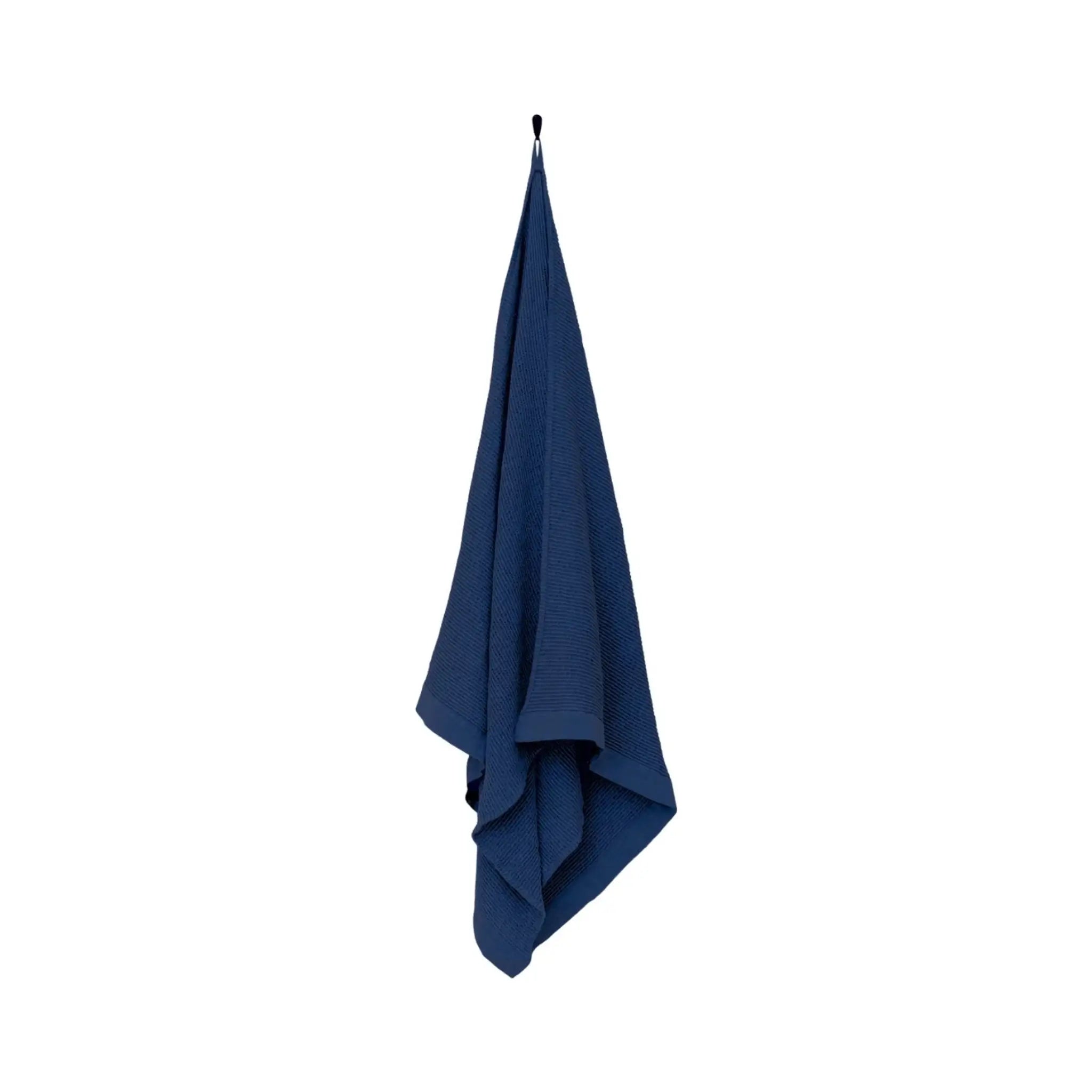 Dark blue large bath towel hanging on a white background with textured weave and wide border