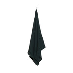 Dark green large bath towel hanging on a white background with textured recycled cotton blend fabric