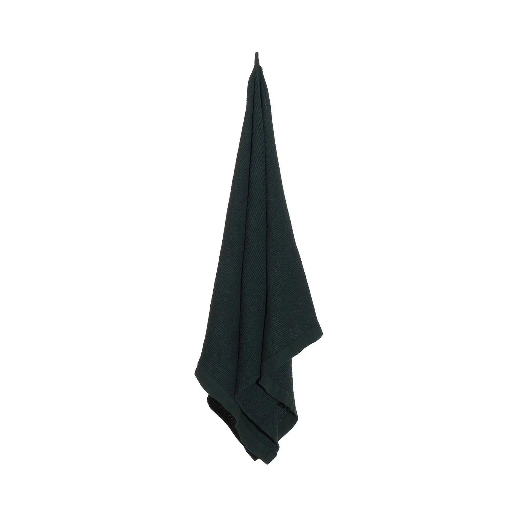 Dark green large bath towel hanging on a white background with textured recycled cotton blend fabric