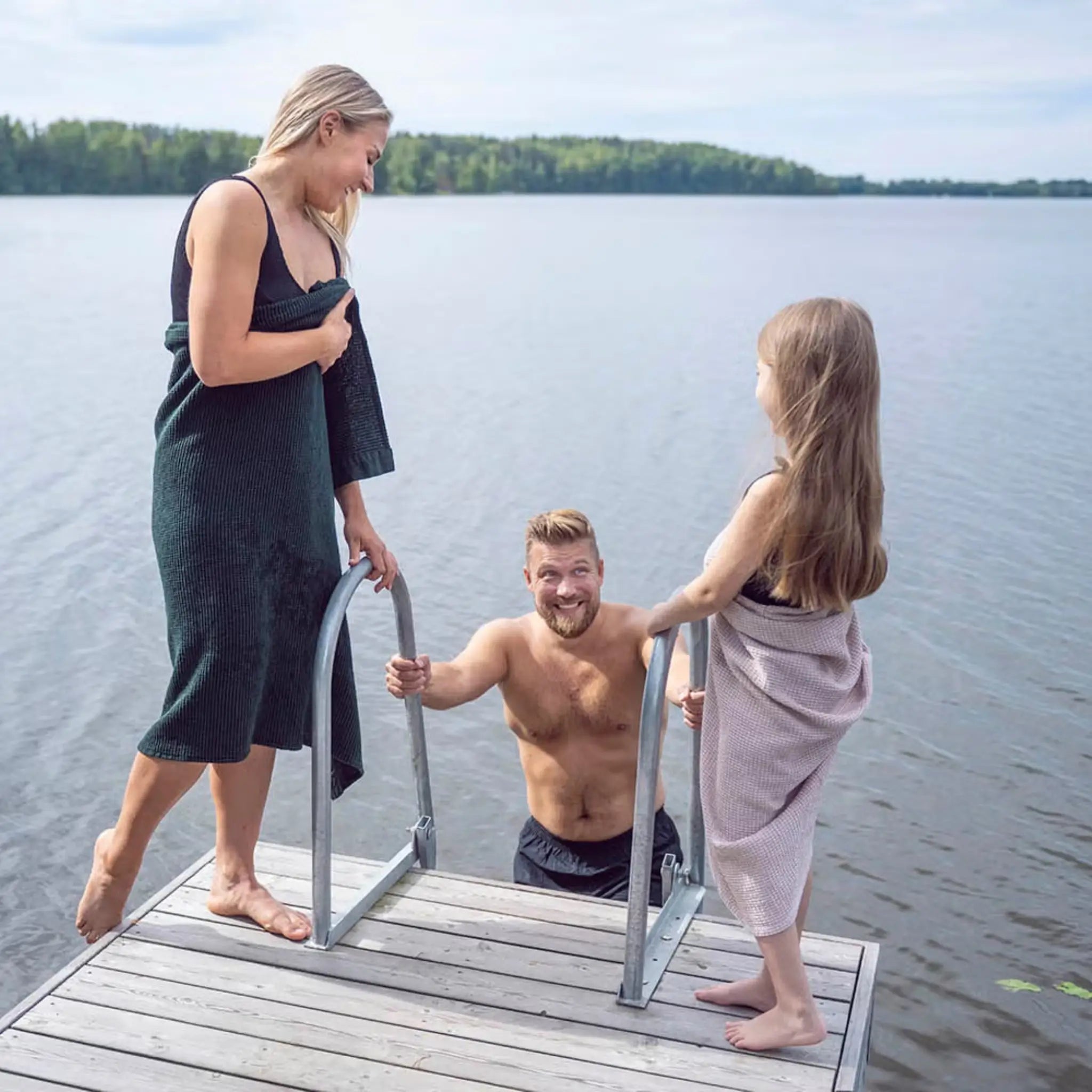 Family by a lake using dark green and pale pink waffle texture towels after swimming