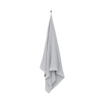 Grey white waffle texture bath towel hanging on a white background with soft recycled cotton blend fabric and chambray edging