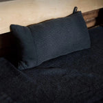 Black Rento Kenno sauna pillow and matching seat cover styled together on a sauna bench