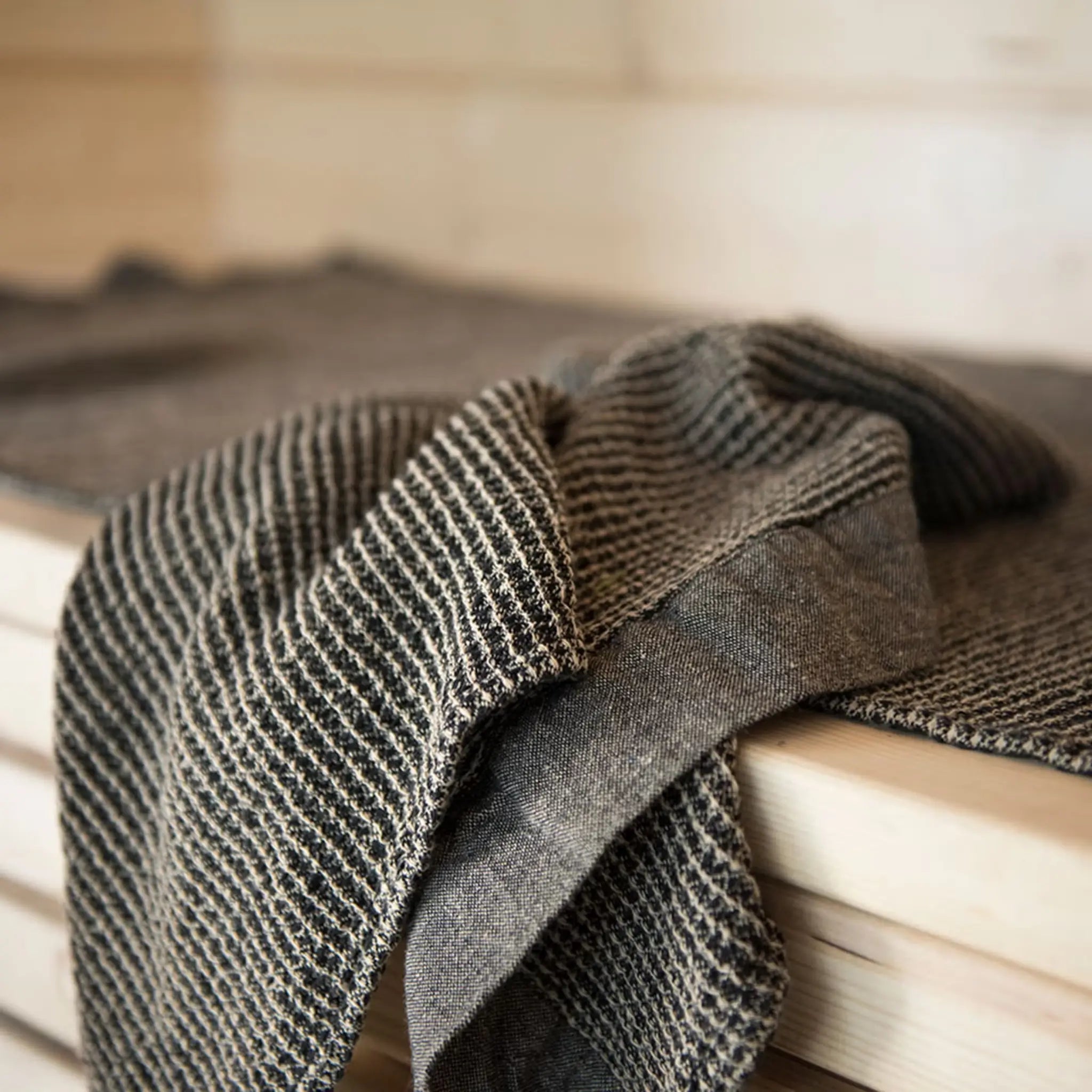 Brown Rento Kenno sauna seat cover with chambray edging on a white background