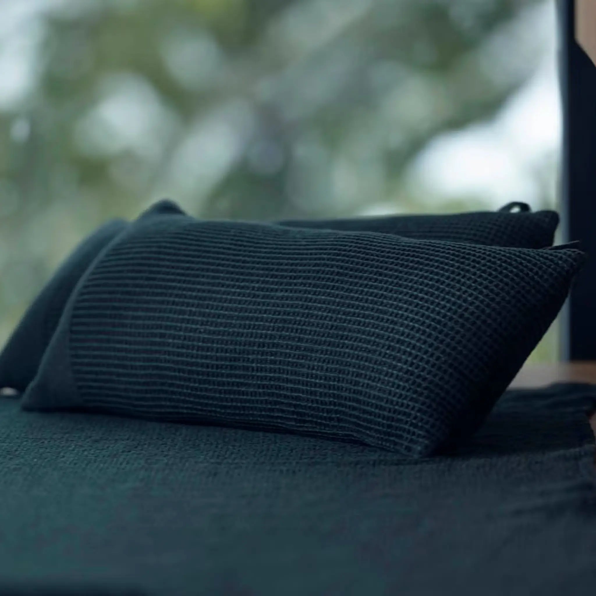 Dark green Rento Kenno sauna pillow and matching seat cover inside a modern sauna room
