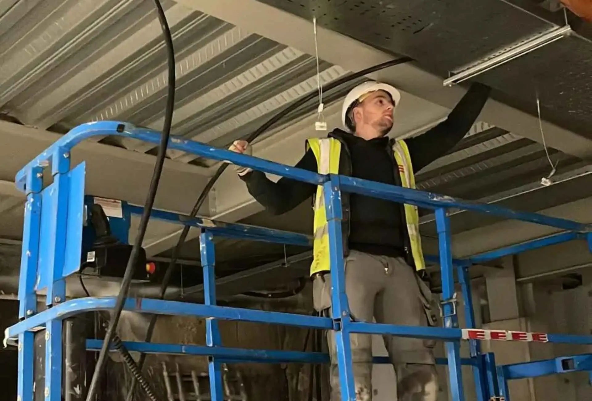 Taylor Glass working at height as an electrician, wiring buildings across the UK and Europe before starting GlampLaunch.