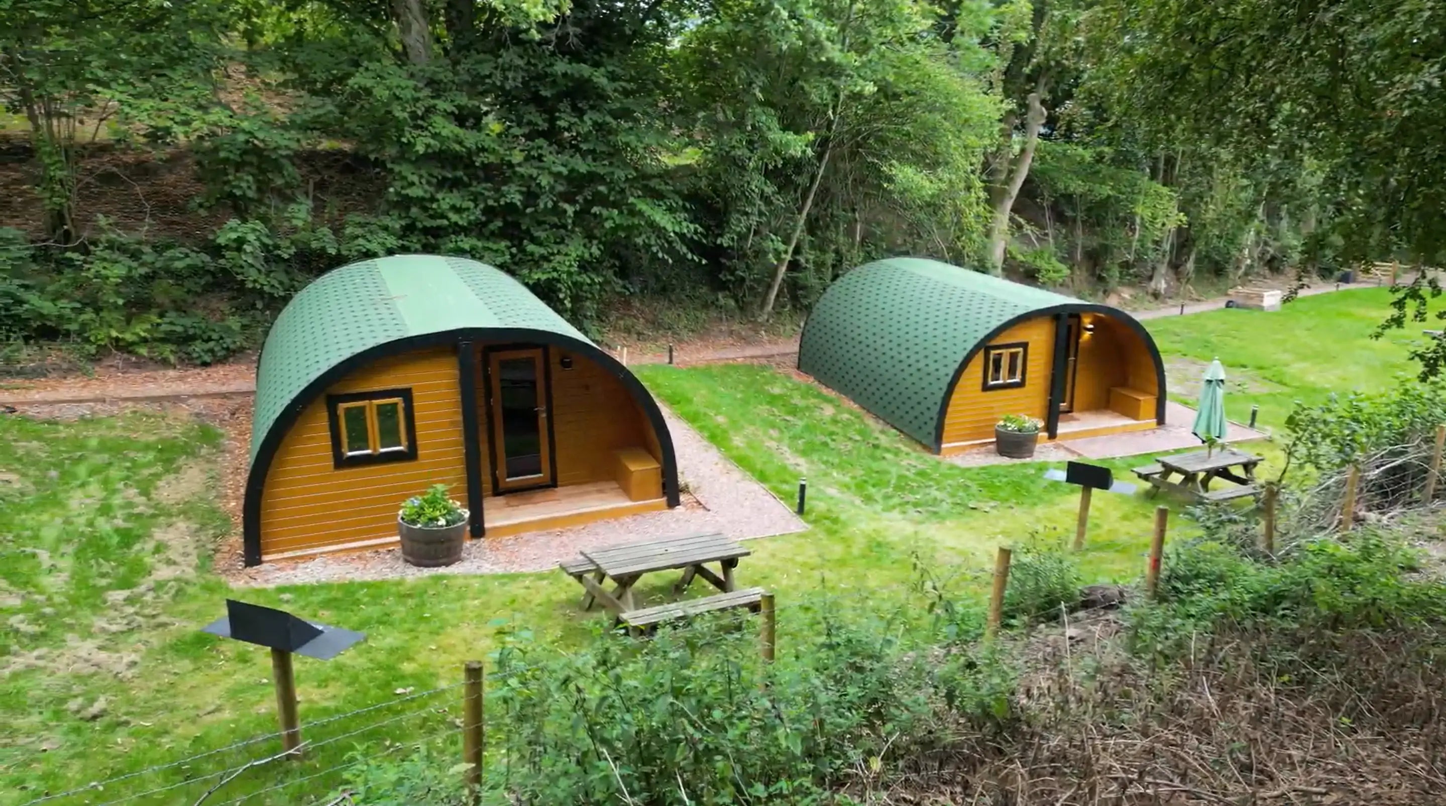Two GlampLaunch glamping pods at The Crown at Pantygelli in the Brecon Beacons, with picnic benches and woodland setting.
