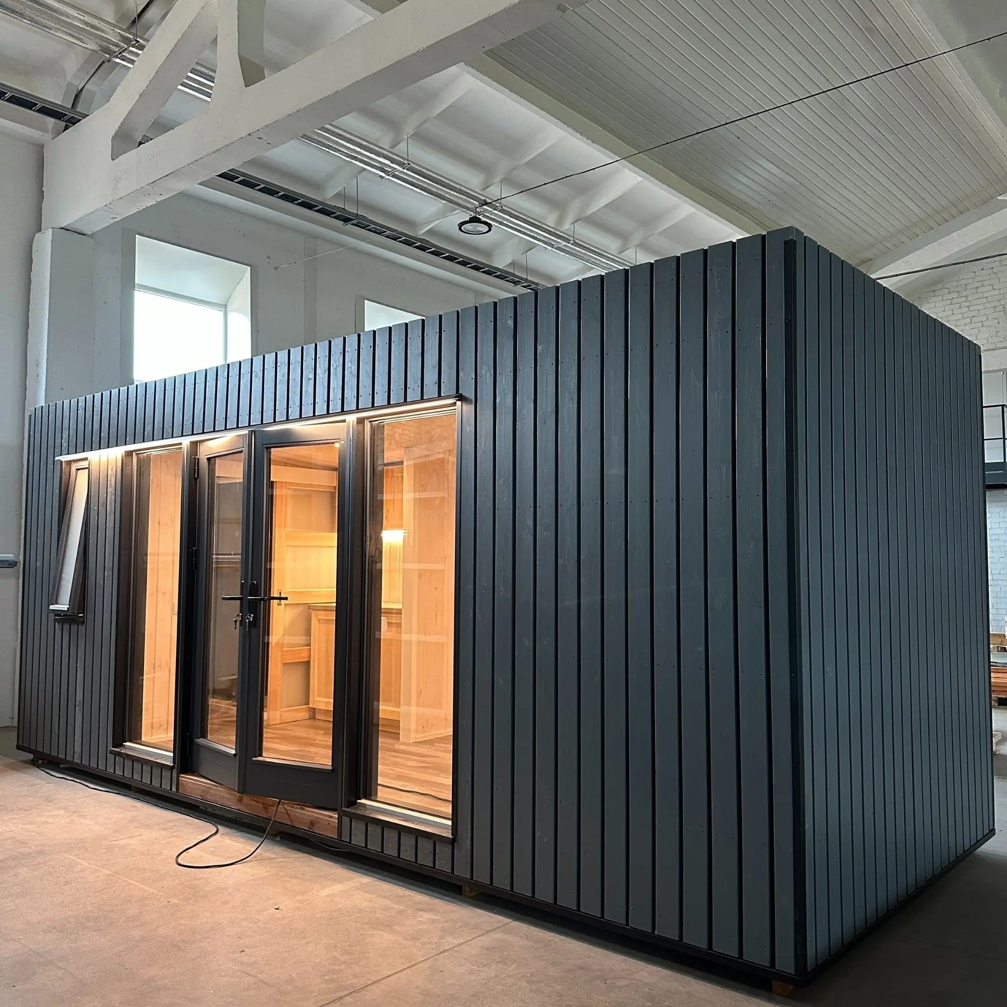 The Large GlampTainer container-style glamping unit – detailed view of right side exterior with sleek cladding and large glass-panel doors