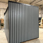 Compact Small GlampTainer container-style glamping structure – enclosed side view with contemporary dark-grey timber cladding and weatherproof exterior.