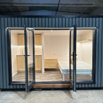 Luxury Small GlampTainer container-style glamping structure – front view with open French doors revealing bright Scandi-style interior and compact kitchenette.