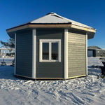 Rear exterior view of the Altura Loft Cabin showing timber cladding and decagon shape