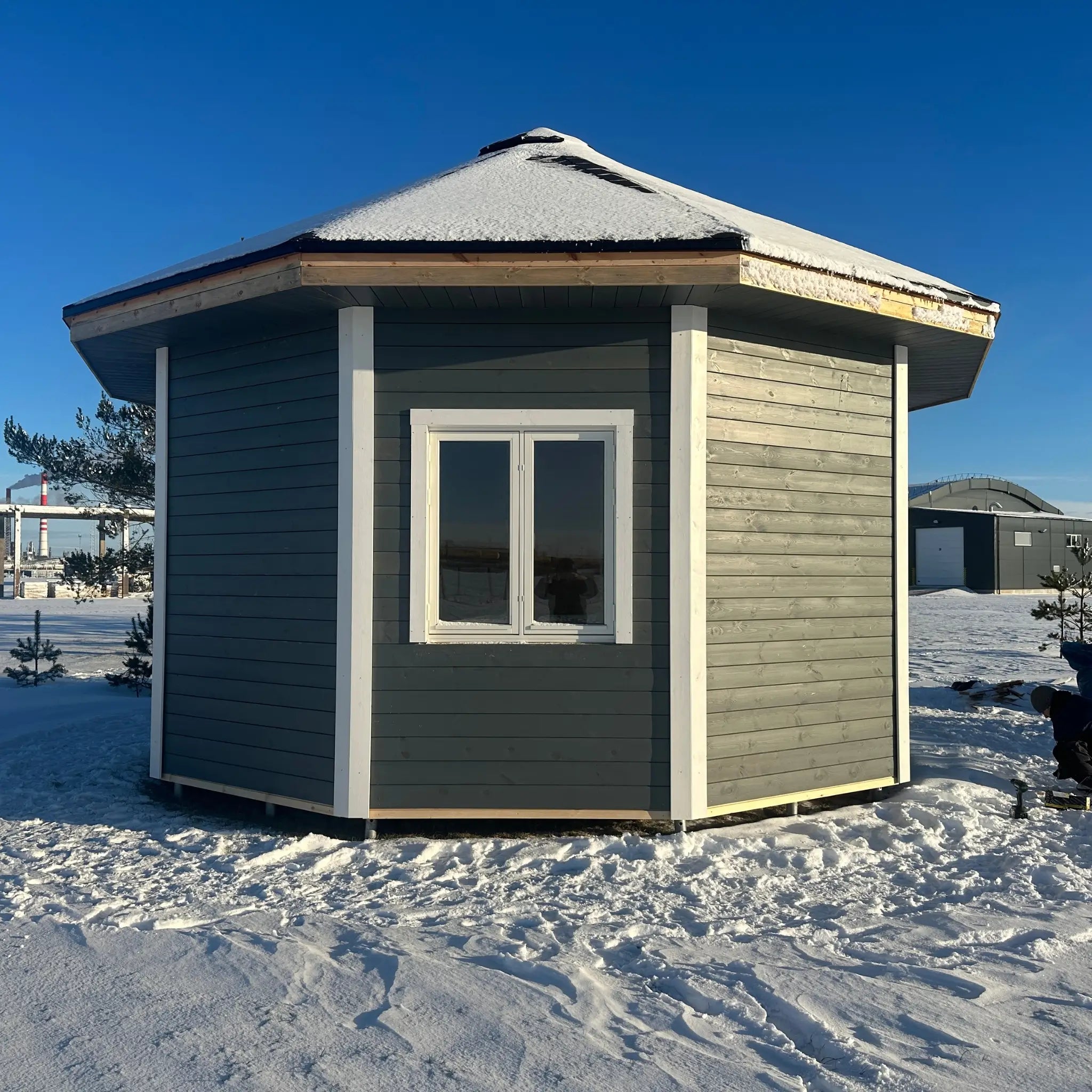 Rear exterior view of the Altura Loft Cabin showing timber cladding and decagon shape
