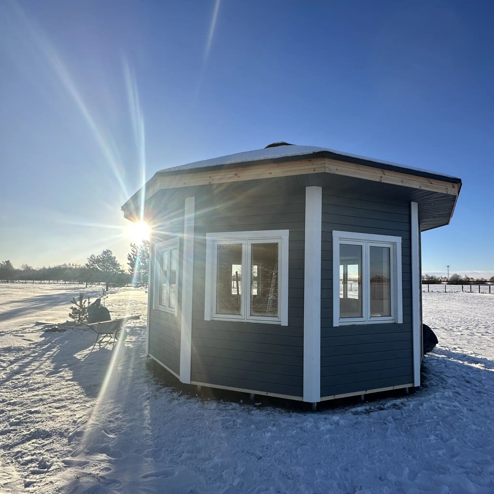 Side exterior view of the Altura Loft Cabin in snow with timber cladding and glazing