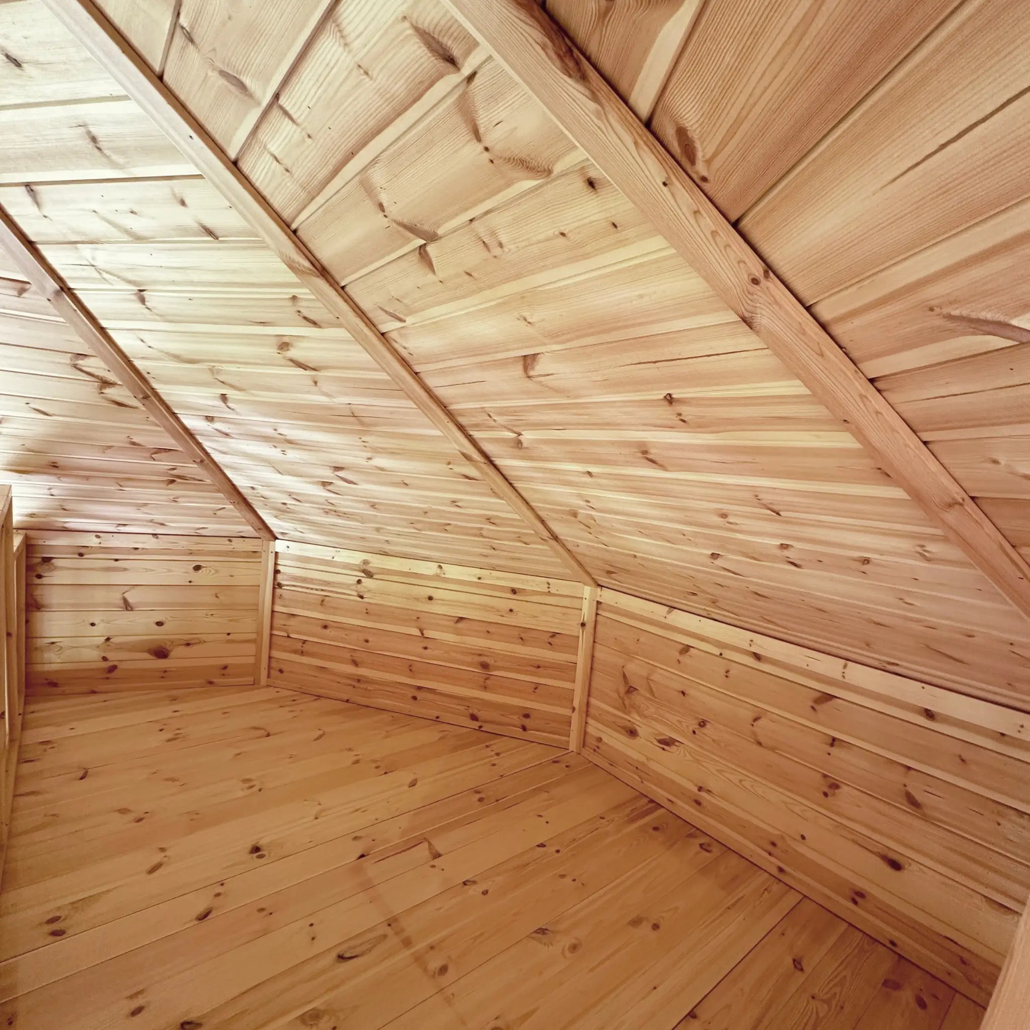Close-up view of the loft sleeping area highlighting timber panelling and angled roof structure